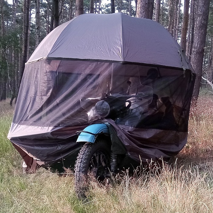 Für schnellen Wetterschutz unterwegs habe ich einen Angelschirm dabei, den ich über dem Motorrad aufspanne. Fixiert wird er mit zwei Ringschrauben am Boot.